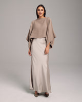 Model wearing a beige alpaca crop top over a long satin skirt