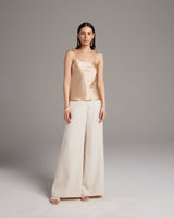 Model wearing a liquid silk tank top with spaghetti straps and wide-leg pants.