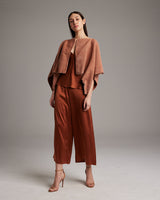 Model wearing a shimmering copper bolero over a matching outfit