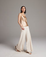 Model wearing a liquid silk tank top with spaghetti straps and wide-leg pants