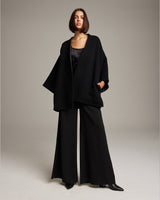 Model wearing a black Flammé Samurai Jacket with wide sleeves and collarless neckline