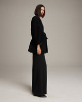 Model wearing a black Flammé Samurai Jacket with wide sleeves and a collarless neckline