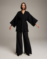 Model wearing a black Flammé Samurai Jacket with wide sleeves and a belt