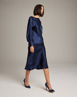 Model wearing a navy Boatneck Blouse in Silk Charmeuse with a flowing fit and bishop sleeves
