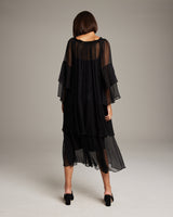 Model wearing a black Cascade Dress, showcasing the back view with layered chiffon sleeves.