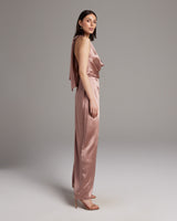 Model wearing a rose-colored convertible halter dress with a dramatic wrap sash