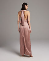 Back view of a convertible halter dress in rose silk with a dramatic wrap sash.
