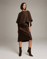 Model wearing a brown alpaca crop top with a brown satin skirt and brown boots