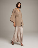 Model wearing a beige Flammé Samurai Jacket over a satin dress
