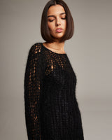 Model wearing a black Open Mesh Boatneck Sweater with a textured knit design