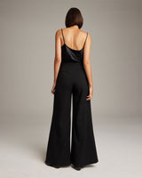 Model wearing black high waist wide trousers, back view