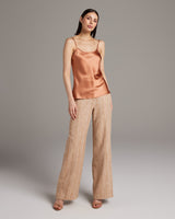 Model wearing a terracotta Liquid Silk Tank with spaghetti straps and palazzo pants.