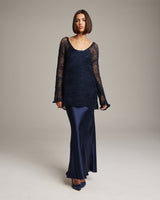 Model wearing a navy loose knit linen sweater with long sleeves and a flowing skirt