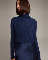 Model wearing a navy Manos Cropped Sweater over a satin dress