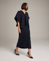 Model wearing a navy poncho over a black skirt, showcasing the Manta Araña design.