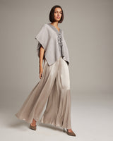 Model wearing a hand-loomed Manta Araña poncho over a long skirt