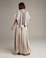 Model wearing a gray poncho with a spider symbol on the back