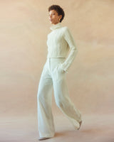 Model wearing an ivory ribbed cropped sweater with wide-leg trousers