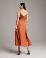 Model wearing an orange Butterfly Wrap Skirt from the back, showcasing its flow and design.
