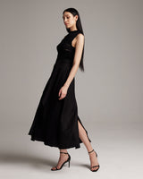 Model wearing a black Butterfly Wrap Skirt, showcasing its flowing design and side slit.