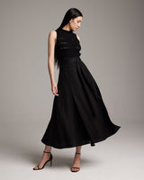 Model wearing a black Butterfly Wrap Skirt with a sleeveless top and heels