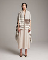 Model wearing a Petite Cascade Wrap with stripes over a beige dress