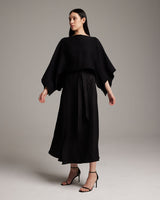 Model wearing a black textured cotton crop top with a long skirt and heels