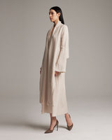 Model wearing a beige Linen Featherlight Wrap Blouse, showcasing its long sleeves and drapey fabric.