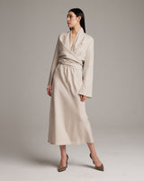Model wearing a beige Linen Featherlight Wrap Blouse with long sleeves and a wrap design.