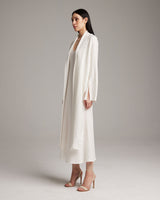 Model wearing a white Linen Featherlight Wrap Blouse, showcasing its drapey fabric and long front sashes.