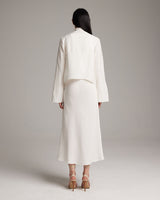 Model wearing a white Linen Featherlight Wrap Blouse from the back