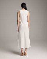 Back view of a model wearing a linen V neck dress in ivory