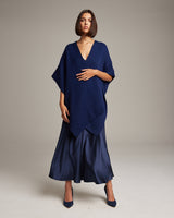 Model wearing a navy solid alpaca duster over a satin skirt