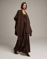 Model wearing a brown alpaca duster over a brown satin dress