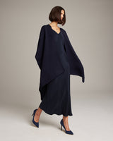 Model wearing a navy solid alpaca duster over a black dress and heels