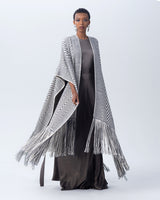 Model wearing a hand-loomed long duster with graphic chevron patterns in ivory and grey.