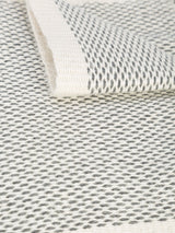 Close-up of Lineas Fringe Scarf showing textured pattern in black and grey