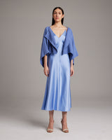 Model wearing a periwinkle textured cotton bolero over a satin dress