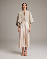 Model wearing a beige Marble Bolero over a satin dress