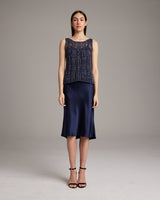 Model wearing a navy Lace Knit Tank with a satin skirt and heels.