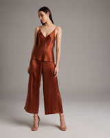 Model wearing a rust V-Neck Silk Cami with wide-leg culottes