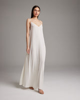Model wearing a flowy ivory Parachute Slip Dress with a cascading drape