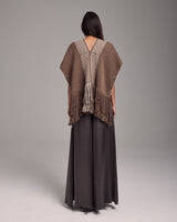 Back view of a person wearing a brown Lineas Fringe Manta with fringes