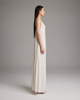 Side view of a model wearing a flowy ivory Parachute Slip Dress, showcasing its cascading drape.