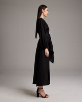 Side view of a woman wearing a black Peasant Blouse Dress with a sash