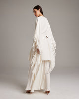 Model wearing a white textured cotton fringe kaftan from the back, showcasing fringe details.