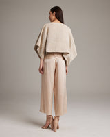 Model wearing a Pearl Crop Top from the back, paired with beige pants.