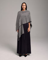 Model wearing a black and ivory Raíz Duster with geometric patterns
