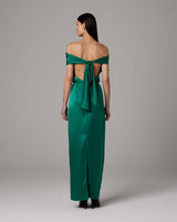 Back view of a model wearing a green convertible halter dress with a tied sash