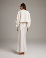 Model wearing a white textured cotton crop top from the back, paired with a long satin skirt.